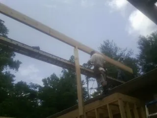 Carpenter setting a ridge beam over a new addition frame — Ice Dam Removal by Roofing Brothers in Pickerington