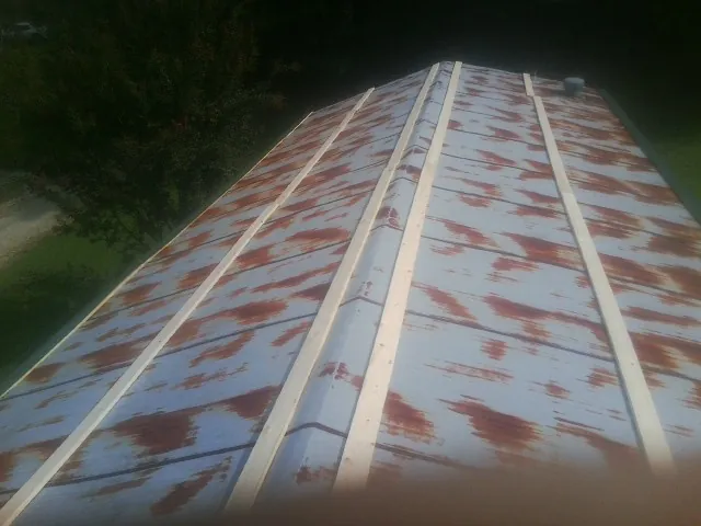 Rusted metal roof panels with new wood purlins before replacement — Storm Damage Roof Repair in Pickerington by Roofing Brothers