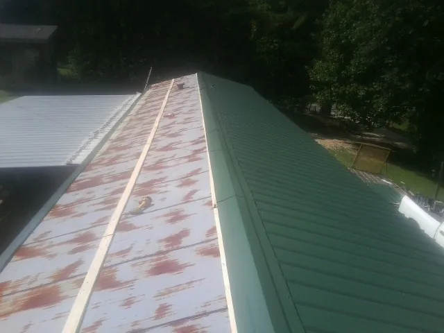 Old rusted panels beside newly installed green metal roofing — Wind Damage Roof Repair by Roofing Brothers in Pickerington