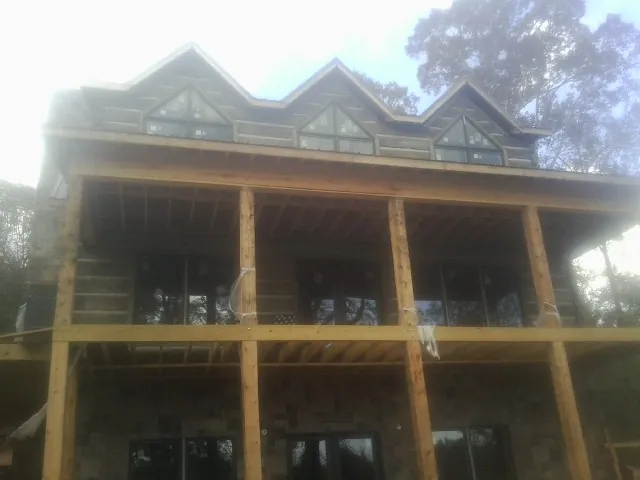 Dormers and porch framing on a large log home under construction — Roof Coating work by our crew in Pickerington
