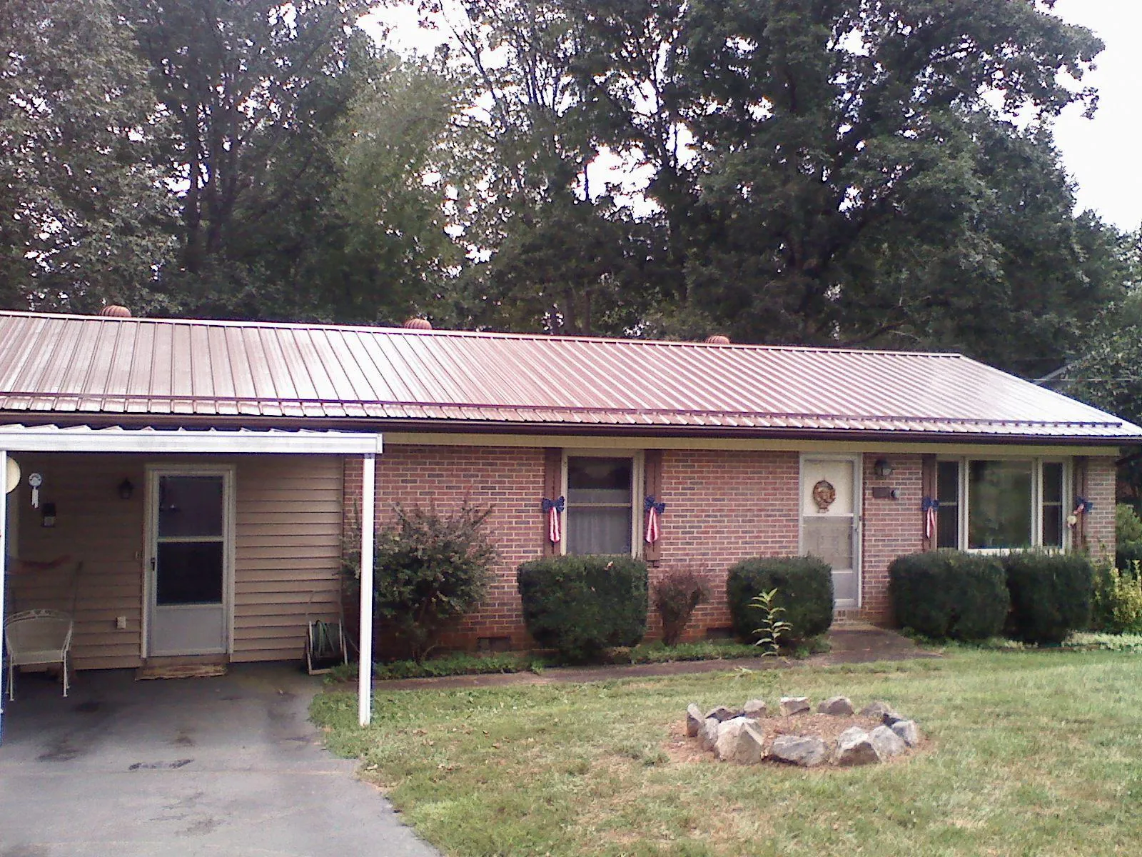 Bronze metal roof and carport on a brick ranch home — Roof Repair work by our crew in Pickerington